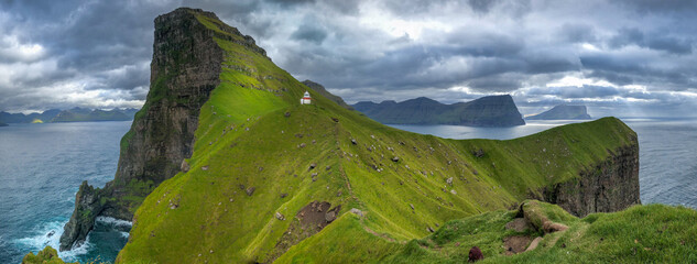 Faroe Islands waterfall Múlafossur near village Gasadalurron the Island Vágar. Green mountain...