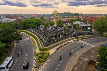 Aerial view of Patung Titi Banda statue at a busy intersection in Denpasar, Bali, Indonesia....