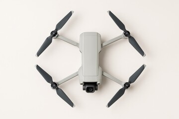 Contemporary aerial drone featuring a camera against a bright backdrop, viewed from above.