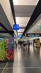 Viena, Austria - May 05, 2025: Modern airport terminal interior with directional signs and colorful...