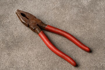 Obraz premium Corroded metal gripping tool lying on concrete surface