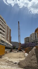 Malaga, Spain - June 23, 2025: Construction site featuring a tall crane, surrounded by buildings...