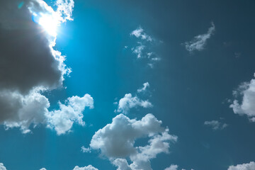 Clear blue sky background with clouds and bright sun. Blue sky and white clouds background. Sunny...
