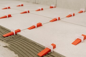 Naklejka na ściany i meble Tile leveling method using clips during mortar setting