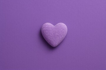 Obraz premium Purple heart-shaped candy on a matching background with a simple love theme