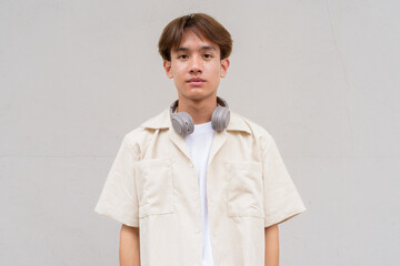 Non binary cute Asian young gay man portrait against studio background
