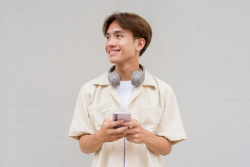 Non binary cute Asian young gay man using phone