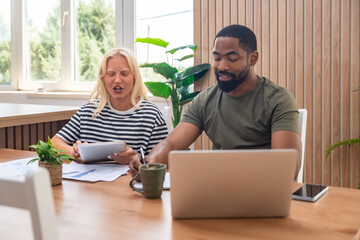 Two young people, couple in relationship, working together at home office. Startup new global...