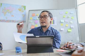 Asian Male Teacher Wearing Glasses Guides Students In The Classroom