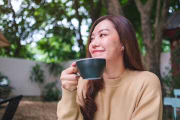 Portrait image of a woman drinking coffee in the outdoors cafe