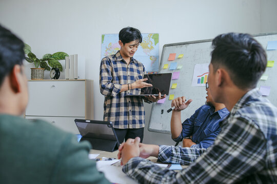 Young Asian Man Presenting Ideas On Laptop And Standing In The Front Of Whiteboard