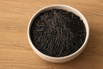 Uncooked Wild Rice Served in a Bowl on a Wooden Surface