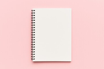 Pink background featuring a school notebook and a spiral notepad on a table with office accessories