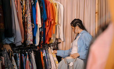 A Fashion Enthusiast is Happily Exploring a Colorful Clothing Rack in a Boutique