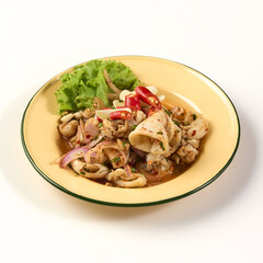 Spicy squid salad with fresh herbs, chili, and lime served on yellow plate garnished with lettuce, creating vibrant and flavorful Thai dish