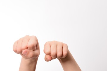Two fists clenched, close-up shot against a white background. A symbol of strength, determination,...