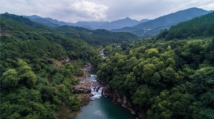 Bird's-eye view of the park's waterfalls, green hills, and idyllic scenery; The wide river flows through lush forests, raindrops falling from high waterfalls, splashes, natural beauty and tranquility.
