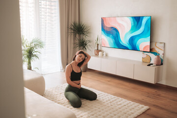 A woman is actively practicing her wellness routine in a modern living room space