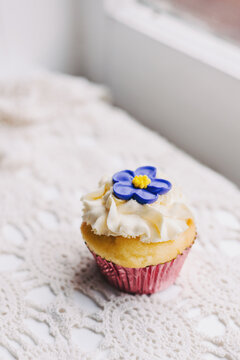 vintage style cupcake on doily with purple flower