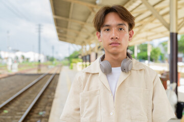 Young non binary tourist traveler in train station