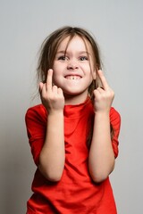 Girl in red shirt making a rude gesture. Playful, mischievous expression.
