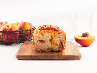 Peach cake loaf on wooden cutting board on white backgroud