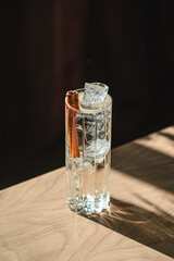 Crystal clear cocktail with ice cubes and cinnamon stick