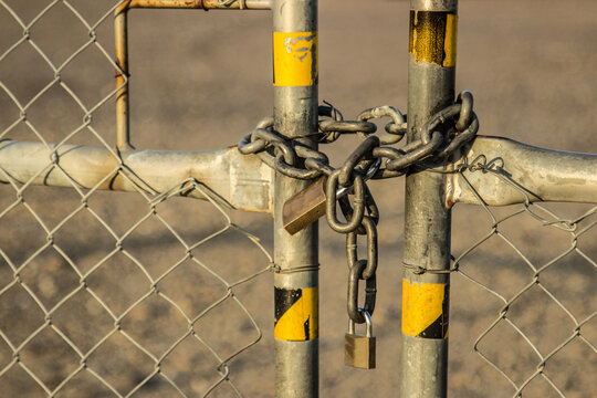 Chain and padlocks holding a gate in an industrial state closed