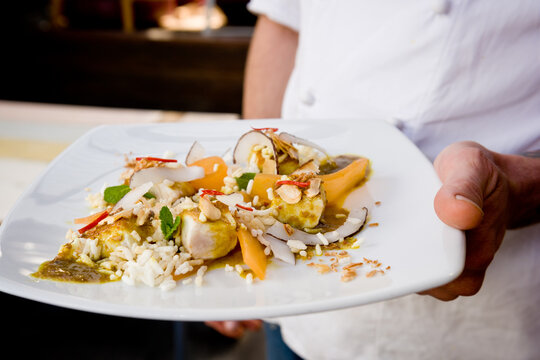 chef holding plate of food