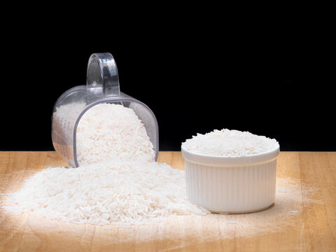 White Rice in Measuring Cup and Bowl on Wooden Surface