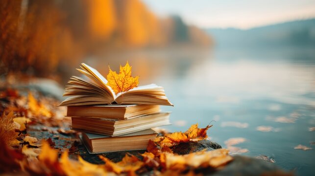 A stack of books with autumn leaves rests near a calm lakeshore, surrounded by vibrant fall foliage and soft, warm sunlight - Powered by Adobe