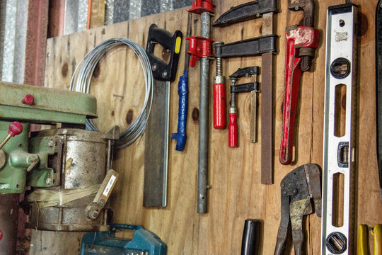 Collection of tools hang on a board in the shed