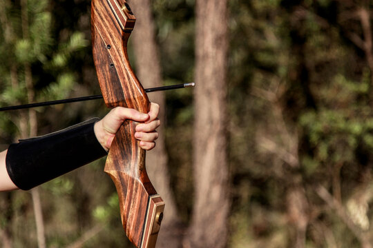 Girl shooting an arrow with a takedown recurve bow