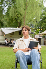 Young non binary person having road trip and camping with friends in nature
