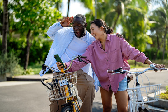 Interracial couple embracing technology, diverse couple enjoying vacation travel relaxation - Powered by Adobe