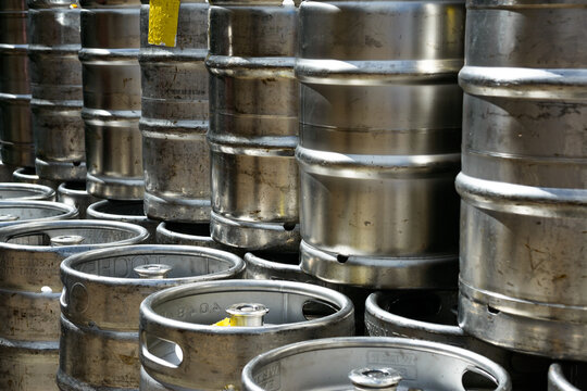 Closeup of metal beer kegs stacked in rows