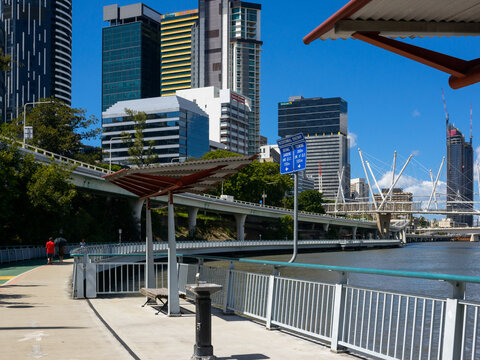 Riverside shared pathway with drinking fountain, shelter and pedestrian in the background.