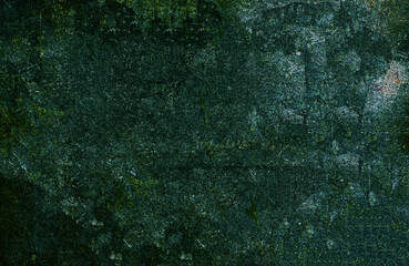 Dark green grunge background showing a textured surface with scratches and stains