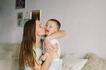 Home portrait of a baby boy with mother on the bed relaxing and playing in the bed at the weekend...