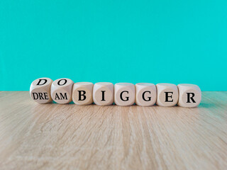 Dream and do bigger symbol. Turned the cubes and changes words dream bigger to do bigger. Business...