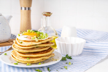 Tasty savory breakfast pancakes with spring green onion and fried eggs