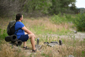 
A man with a backpack walks through the forest and the beach and does sports