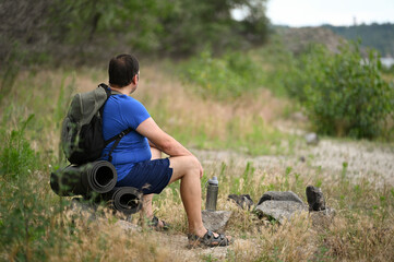 Fototapeta premium A man with a backpack walks through the forest and the beach and does sports