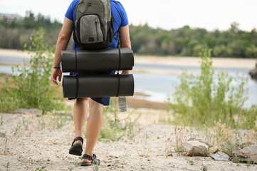 
A man with a backpack walks through the forest and the beach and does sports