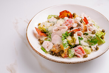 Fresh salad with chicken, tomatoes, and cheese served in a bowl