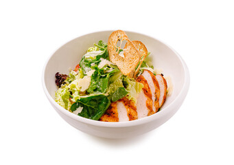 Grilled chicken salad served in a white bowl with crispy greens