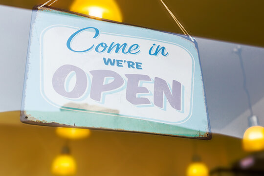 An open sign hanging in a window