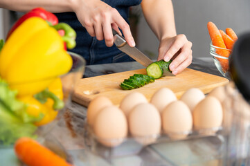 Unrecognizable Caucasian woman cooking healthy lunch, woman cooking tasty food at home, cutting...