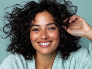 Happy mixed race woman in bathrobe smiling in studio