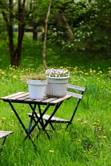 Meble ogrodowa w zielonym ogrodzie. Mała architektura ogrodowa. Miejsce wypoczynku w ogrodzie. Zielony ogród